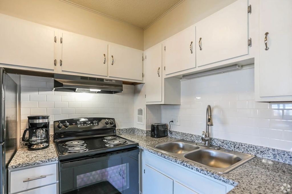 8 Lakeview Gardens, Unit 6 Natick, MA 01760 - Photo 5 of 13 a kitchen with white cabinets and a stove top oven