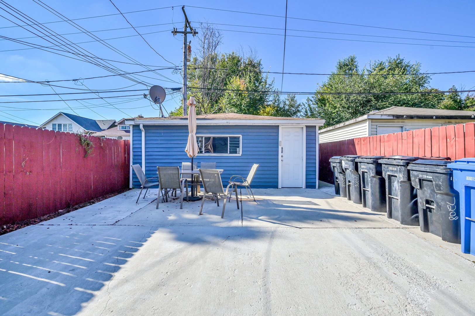 7208 South Eberhart Avenue Chicago, IL 60619 - Photo 19 of 20 a view of a patio with table and chairs potted plants and wooden fence
