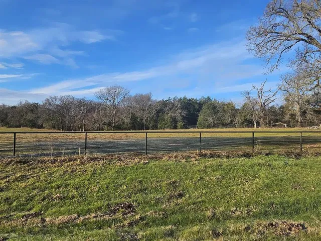a view of a yard with wooden fence