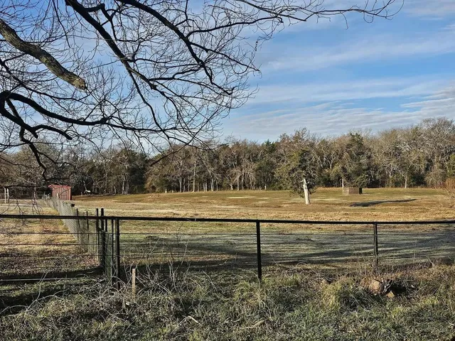 a view of a yard with wooden fence