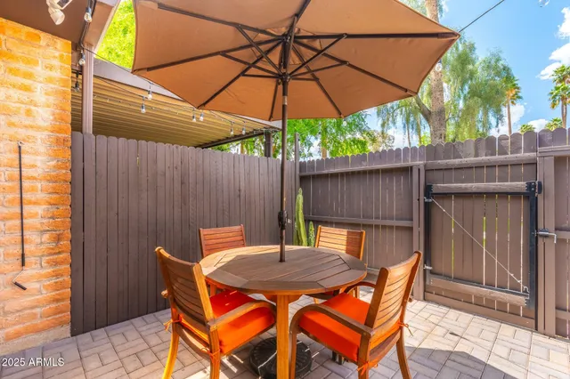 an outdoor sitting area with furniture and umbrella