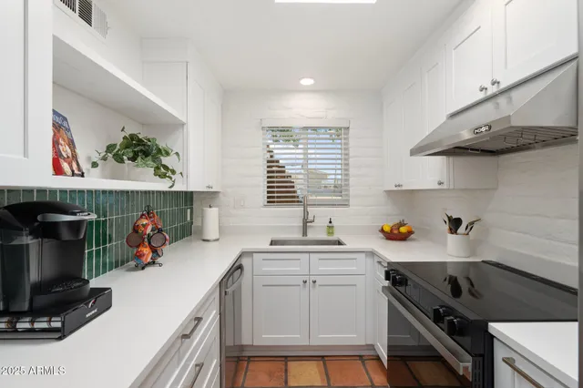 a kitchen with a sink a stove and cabinets