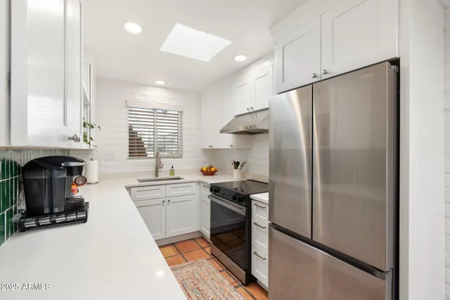 a kitchen with stainless steel appliances a refrigerator sink and cabinets