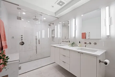 a bathroom with a double vanity sink mirror and shower