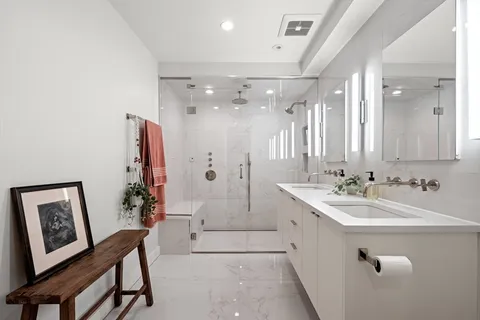 a spacious bathroom with a double vanity sink mirror and shower
