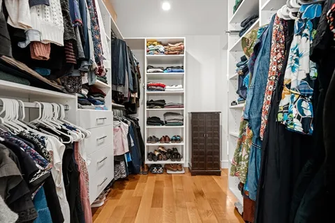 a view of walk in closet with clothes and shoes