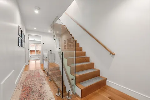 a view of entryway and hall with wooden floor