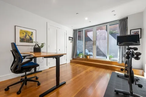 a view of a workspace with furniture and a window