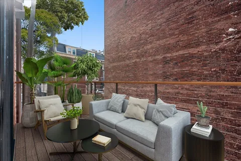 a balcony with furniture and a potted plant