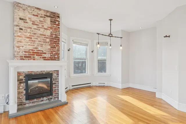 a view of an empty room with a fireplace and a window