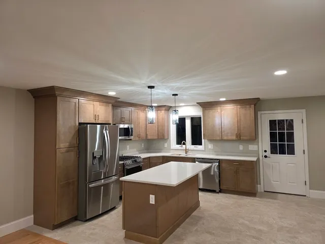 a large kitchen with cabinets and stainless steel appliances