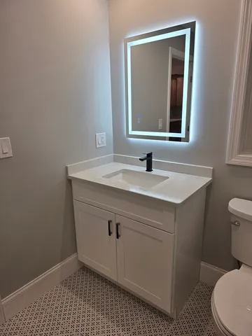 a bathroom with a sink a toilet and mirror