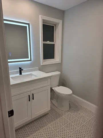a bathroom with a sink a toilet and mirror
