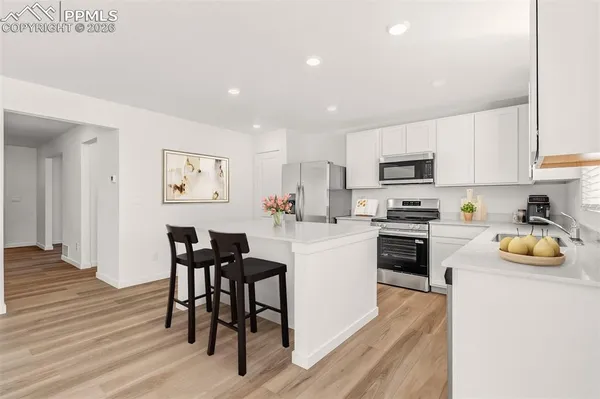 a kitchen with white cabinets and appliances