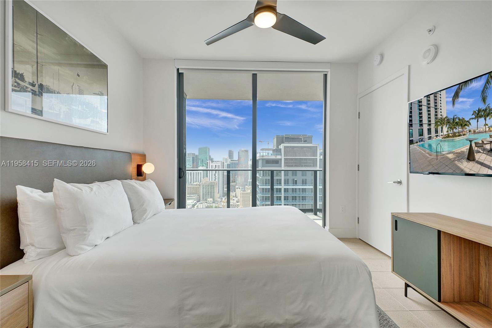 159 Northeast 6th Street, Unit 3405 Miami, FL 33132 - Photo 14 of 37 a bedroom with a large bed and a window