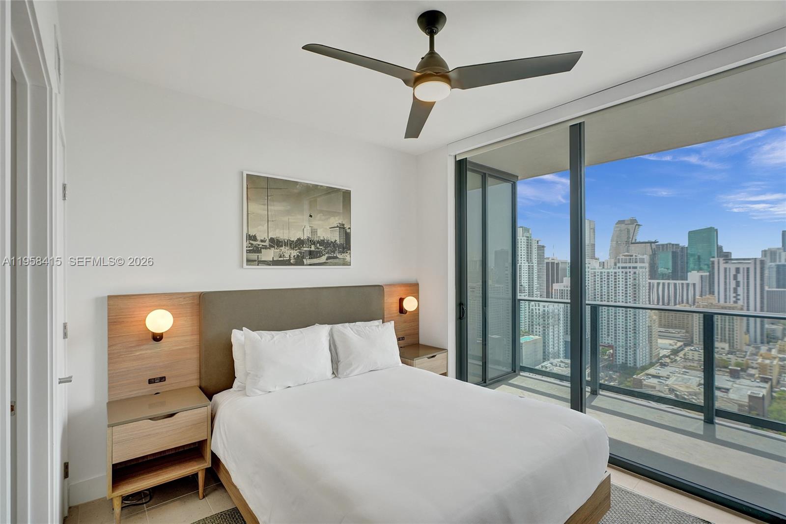 159 Northeast 6th Street, Unit 3405 Miami, FL 33132 - Photo 15 of 37 a bedroom with a large bed and a chandelier