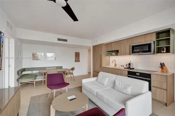 a living room with furniture kitchen view and a flat screen tv