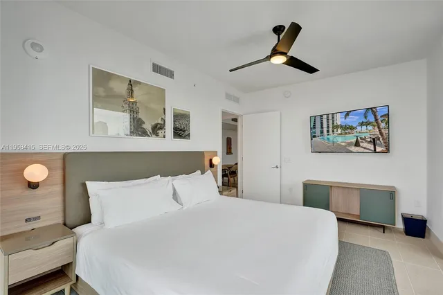 a bedroom with a large bed and a chandelier