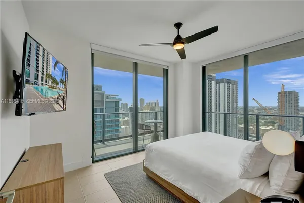 a bedroom with a large bed and a chandelier