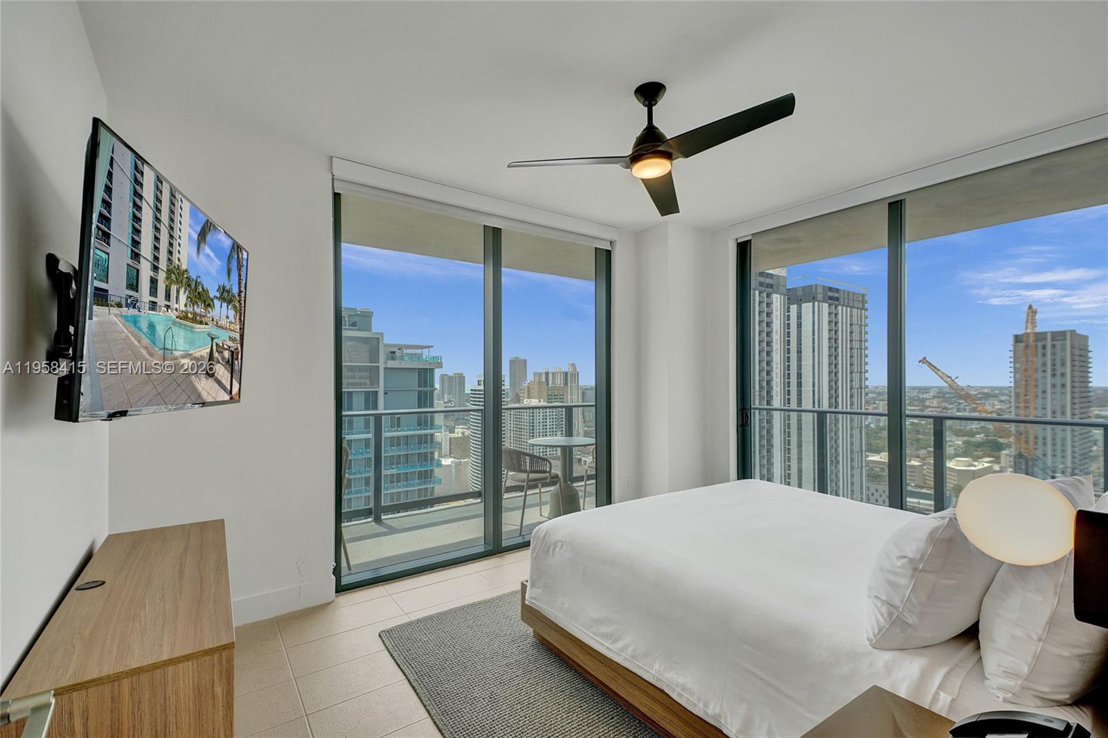 159 Northeast 6th Street, Unit 3405 Miami, FL 33132 - Photo 9 of 37 a bedroom with a large bed and a chandelier