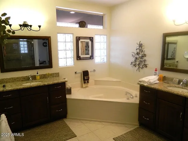 a bathroom with a tub sink and mirror