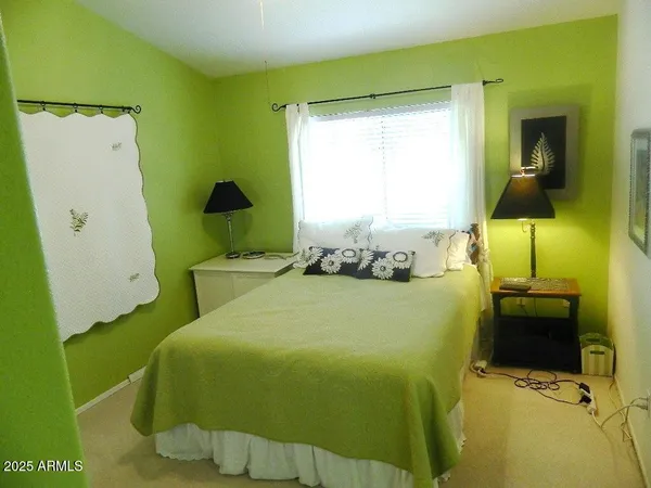 a bedroom with a bed and teddy bear on bed