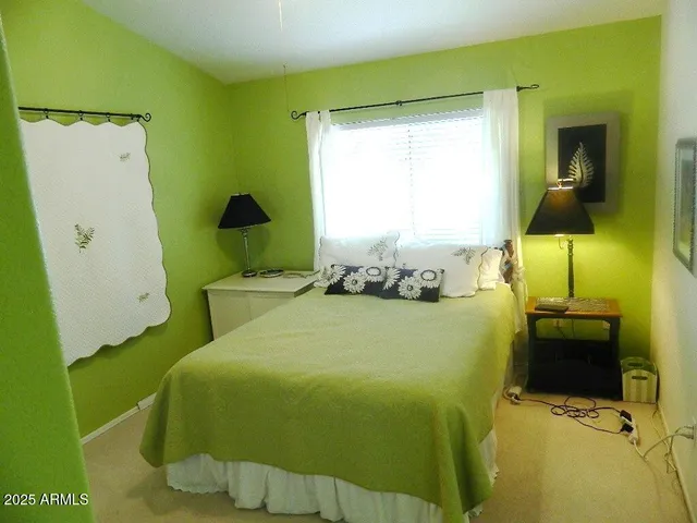 a bedroom with a bed and teddy bear on bed