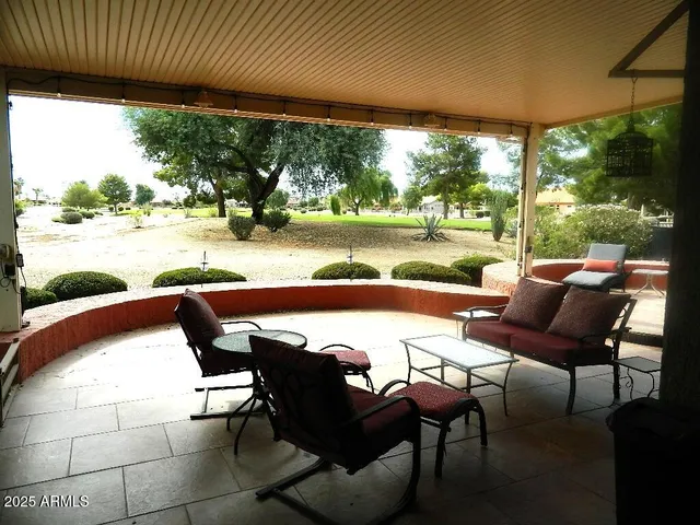 a view of a swimming pool with lawn chairs and a table
