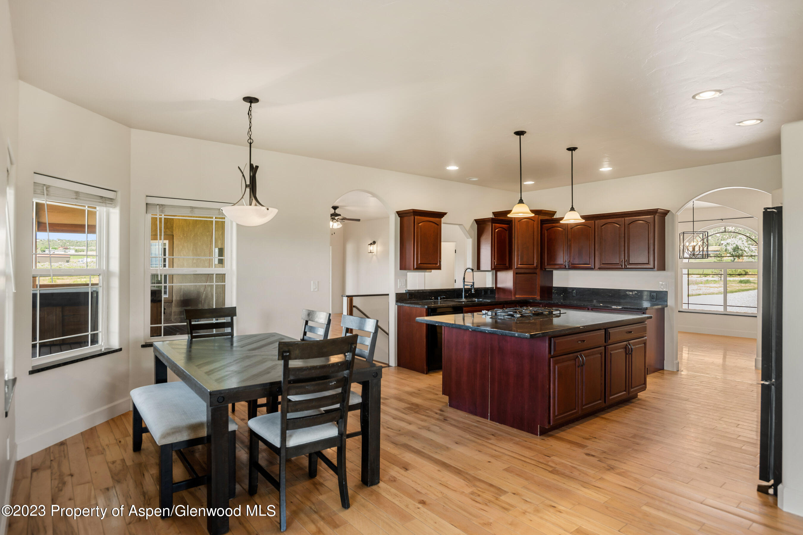 1148 County Road 237 Silt, CO 81652 - Photo 11 of 80 a kitchen with stainless steel appliances granite countertop a stove top oven a sink dishwasher a dining table and chairs with wooden floor
