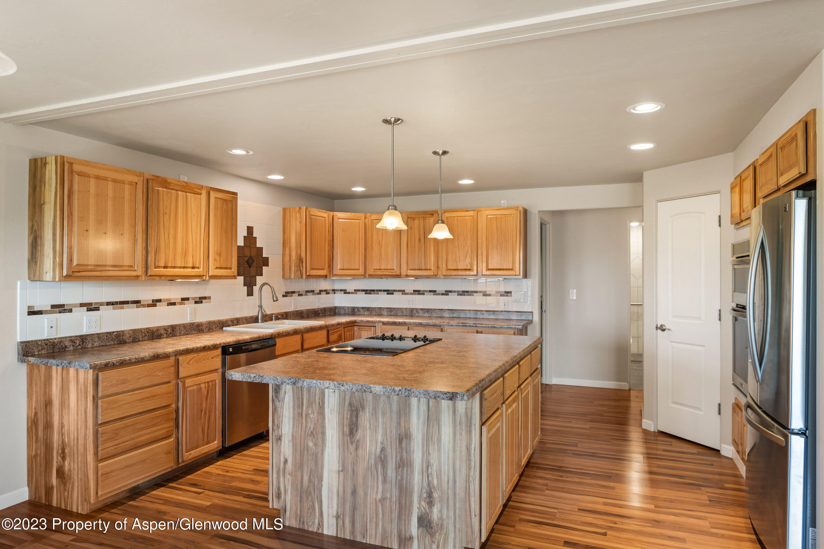 1148 County Road 237 Silt, CO 81652 - Photo 30 of 80 a kitchen with a stove a sink a refrigerator and cabinets