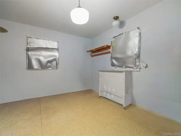 a spacious bedroom with a bed and a chandelier