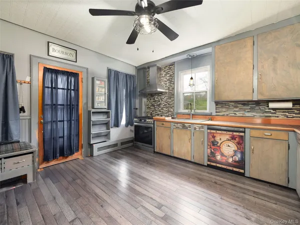 a kitchen with stainless steel appliances granite countertop a stove a sink dishwasher and a refrigerator with wooden floor