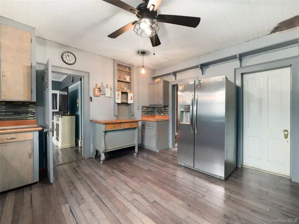 a kitchen with stainless steel appliances a refrigerator a sink and wooden floor