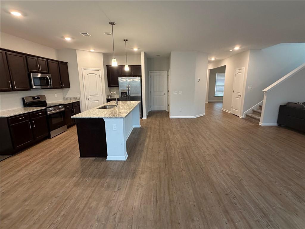 16 Jazz Drive Pooler, GA 31322 - Photo 7 of 17 a large kitchen with stainless steel appliances kitchen island granite countertop a large counter top and wooden floors