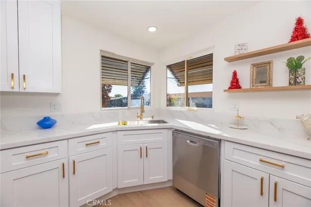 a large kitchen with stainless steel appliances lots of white cabinets and a granite counter tops