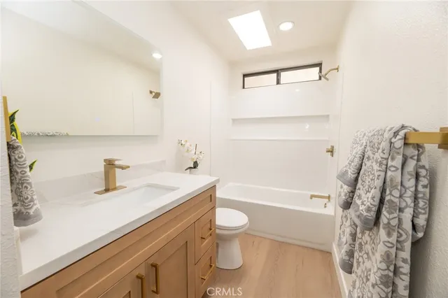 a spacious bedroom with a bed a couch and large window