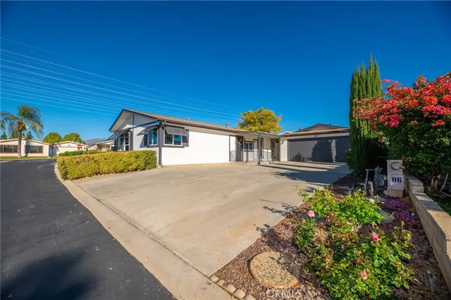 a view of a house with a small yard and floor to ceiling window and potted plants