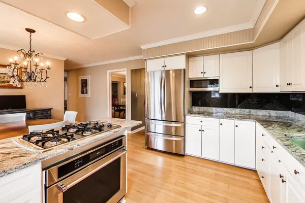 a kitchen with stainless steel appliances granite countertop a stove refrigerator and cabinets