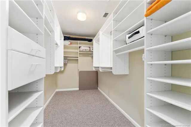 a view of walk in closet with empty racks