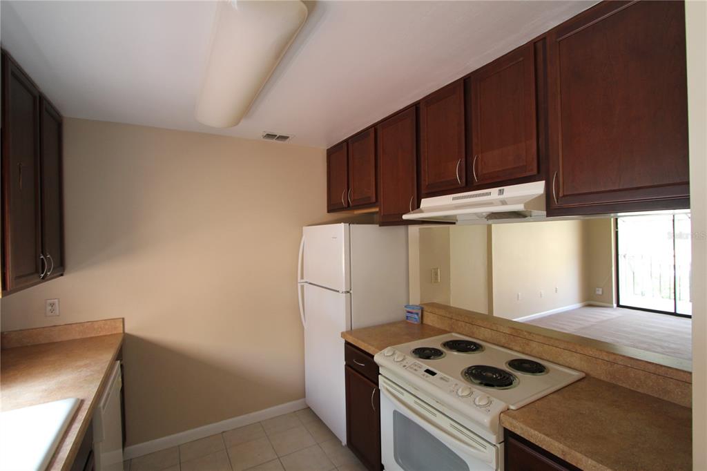 4709 Capri Place, Unit 189 Orlando, FL 32811 - Photo 2 of 9 a kitchen with a cabinets and white stove