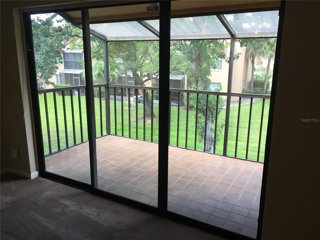 4709 Capri Place, Unit 189 Orlando, FL 32811 - Photo 4 of 9 a bed sitting in a balcony next to a yard