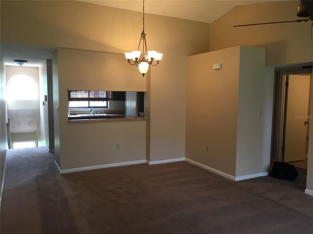 4709 Capri Place, Unit 189 Orlando, FL 32811 - Photo 5 of 9 a view of a livingroom with a chandelier fan and windows