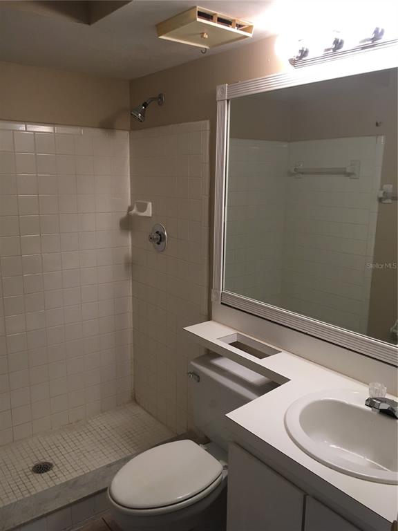 4709 Capri Place, Unit 189 Orlando, FL 32811 - Photo 7 of 9 a bathroom with a sink a toilet and shower