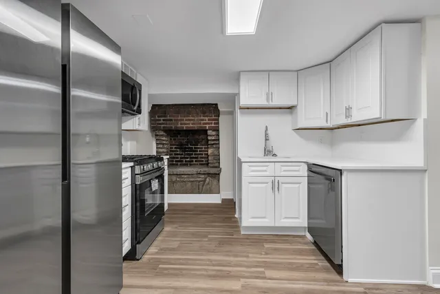 a kitchen with stainless steel appliances kitchen island granite countertop a refrigerator and a stove top oven