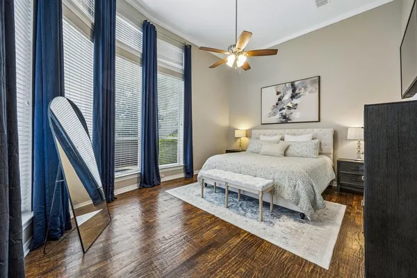 a bedroom with a bed lamp and a large window