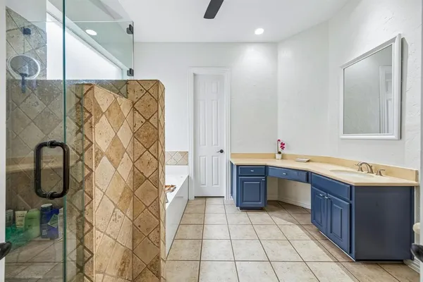 a bathroom with a tub sink and mirror