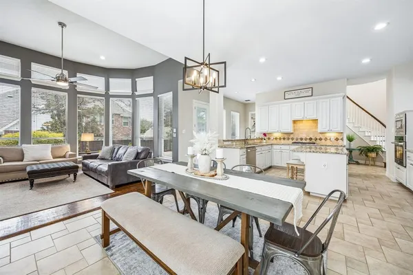 a dining room with furniture a chandelier and wooden floor