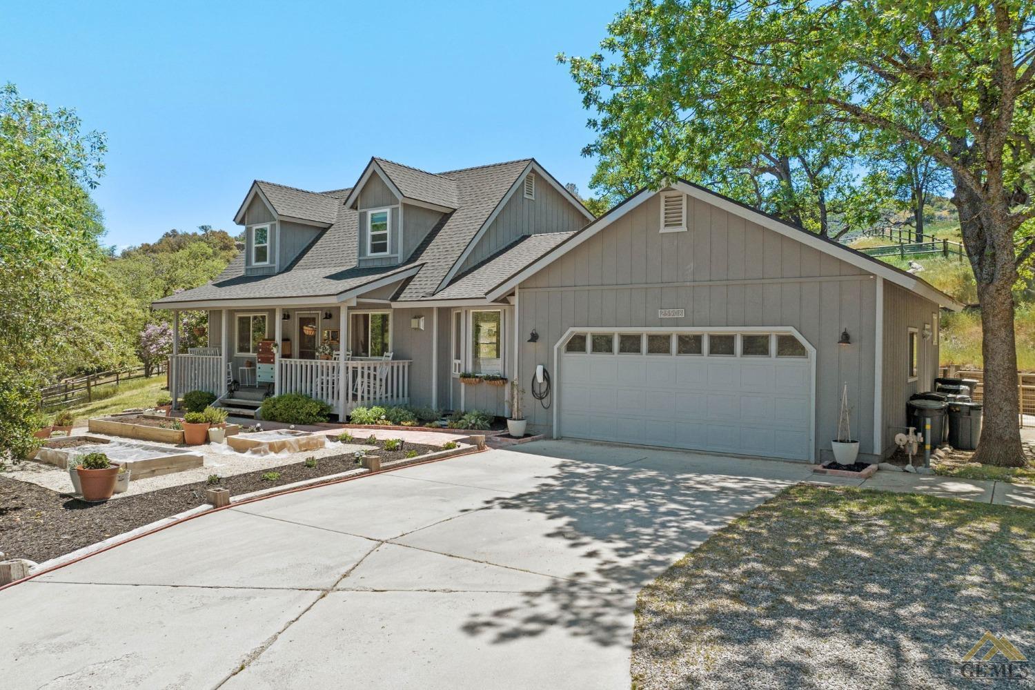 a view of a house with a yard and large tree