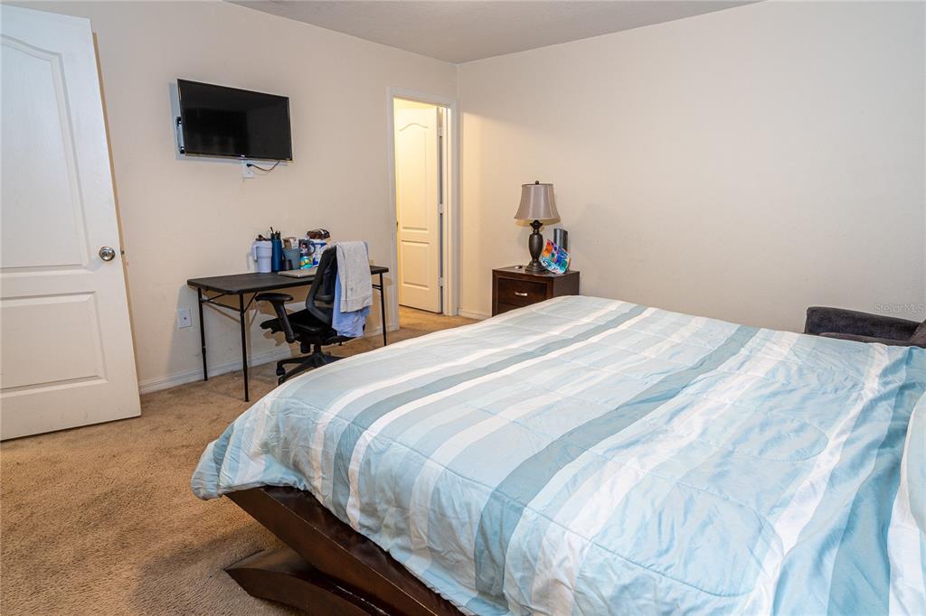 4563 Orchard Grove Road St. Cloud, FL 34772 - Photo 20 of 51 a bedroom with a bed and a flat screen tv