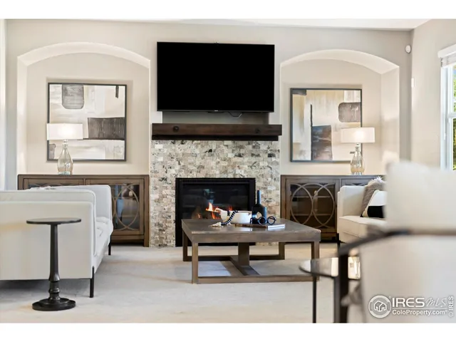 a living room with furniture a flat screen tv and a fireplace